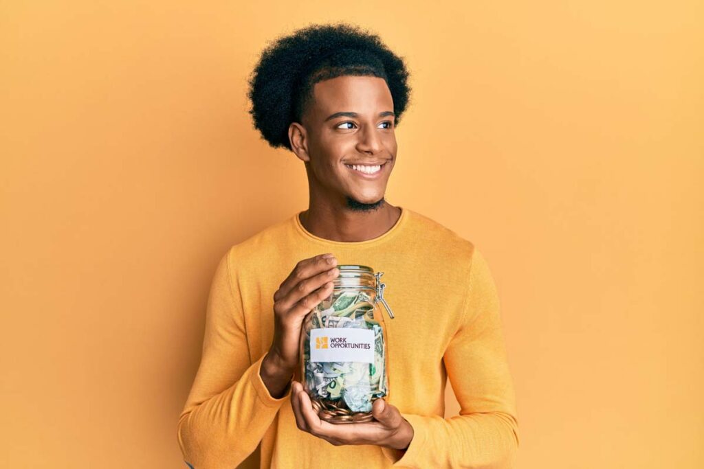 Young African American man holding a donation jar filled with money