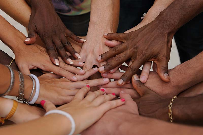group of diverse hands joining together in unity