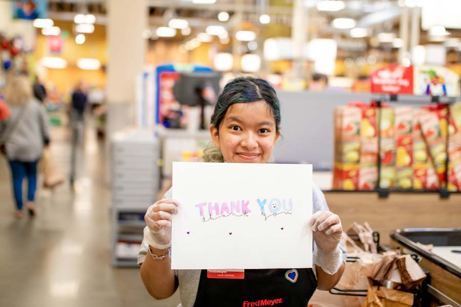 Woman holding up a thank you sign for Work Opportunities